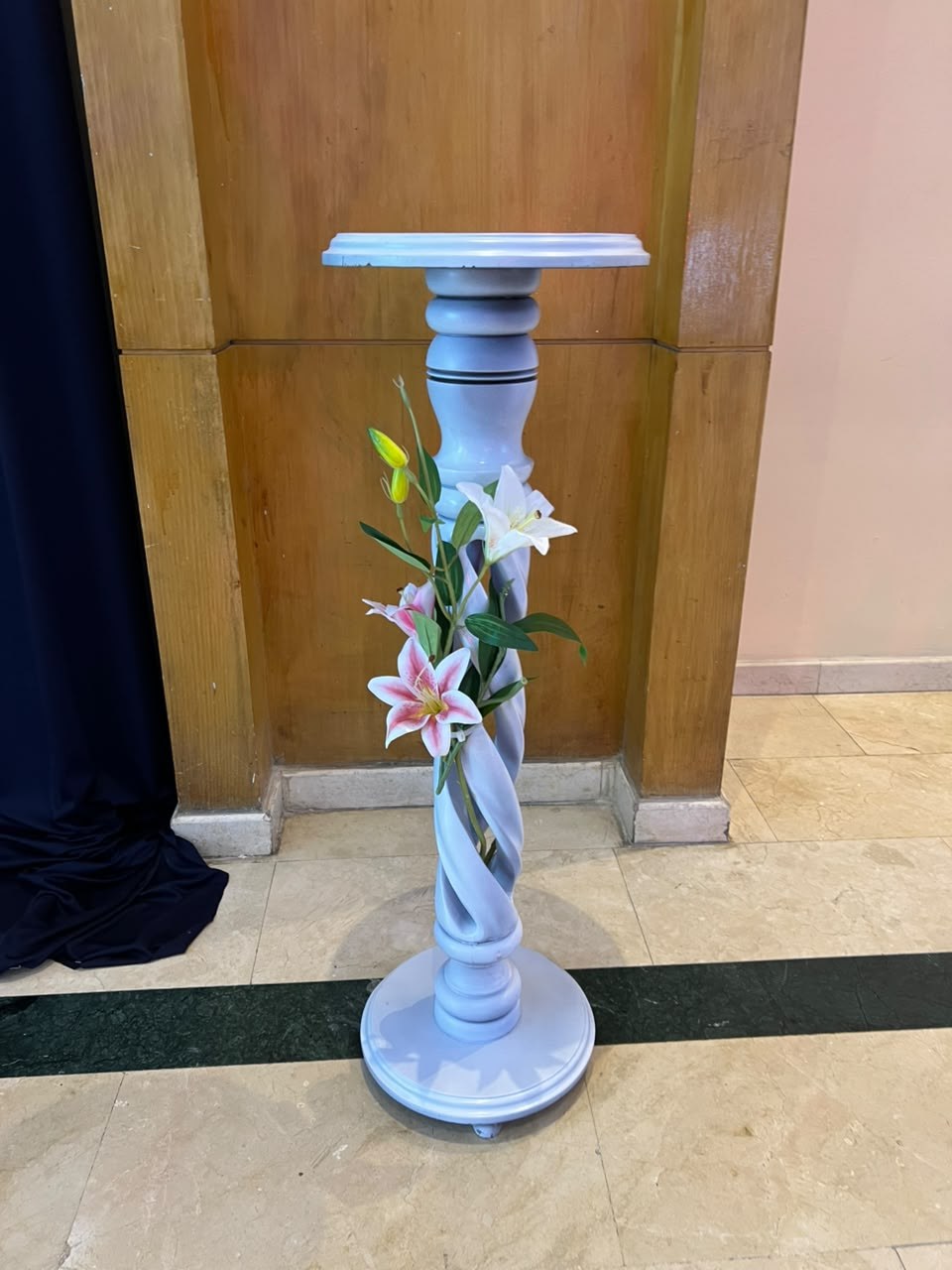 Pedestal blanco con lirios